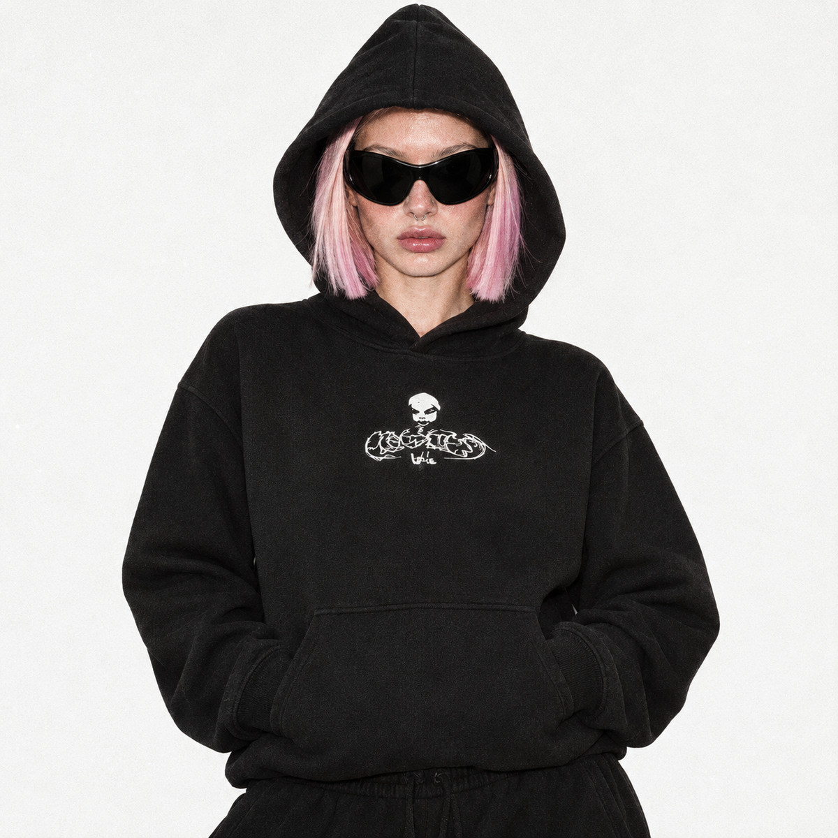 Model in the black fleece hoodie with the white Flawless skull logo, hood up, wearing sunglasses.